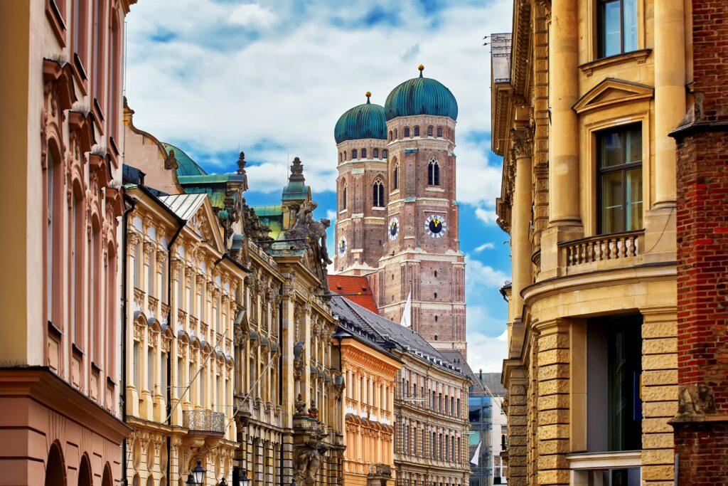 Frauenkirche in Muenchen zwischen historischen Haeuserfassaden in der Altstadt