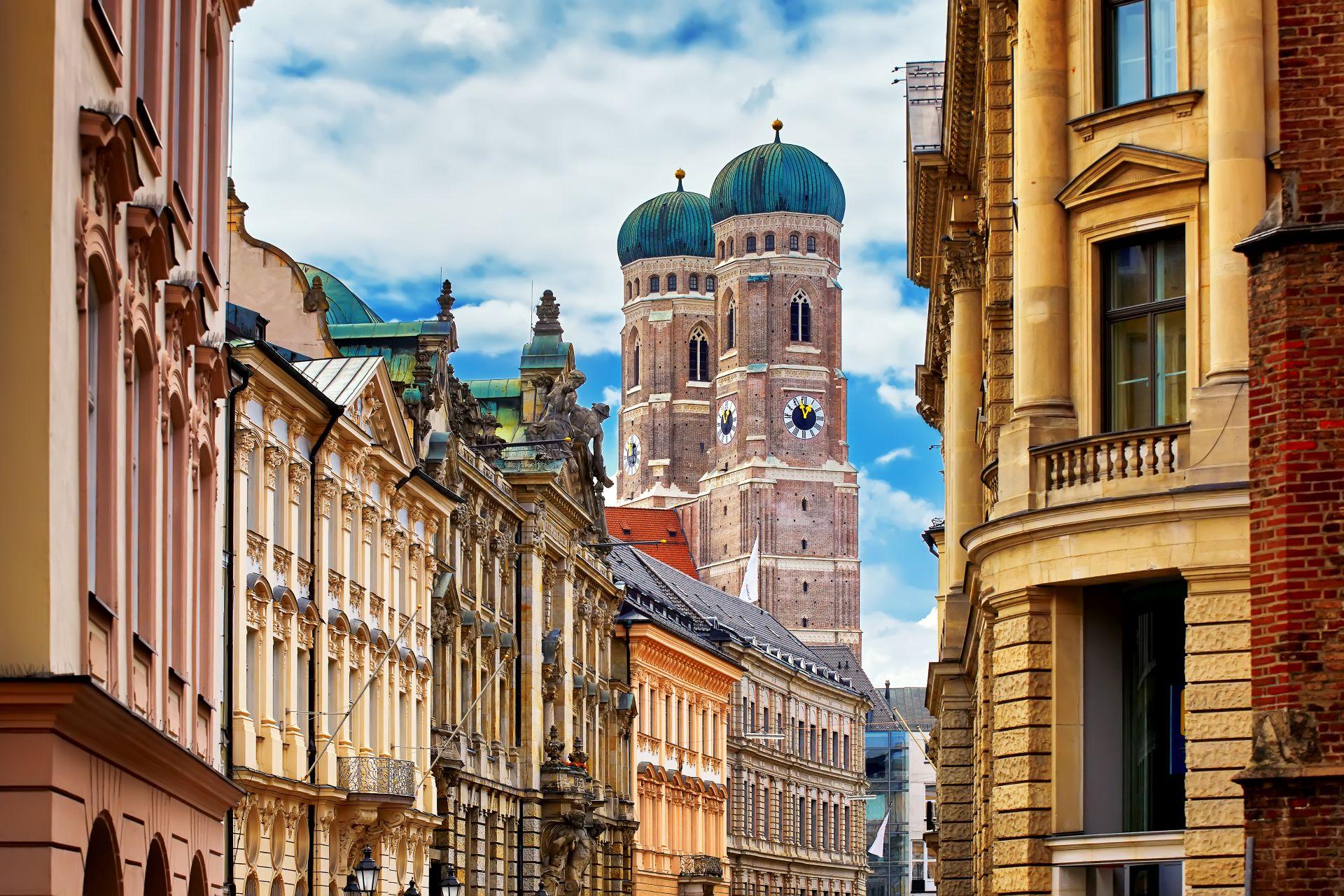 Frauenkirche in Muenchen zwischen historischen Haeuserfassaden in der Altstadt