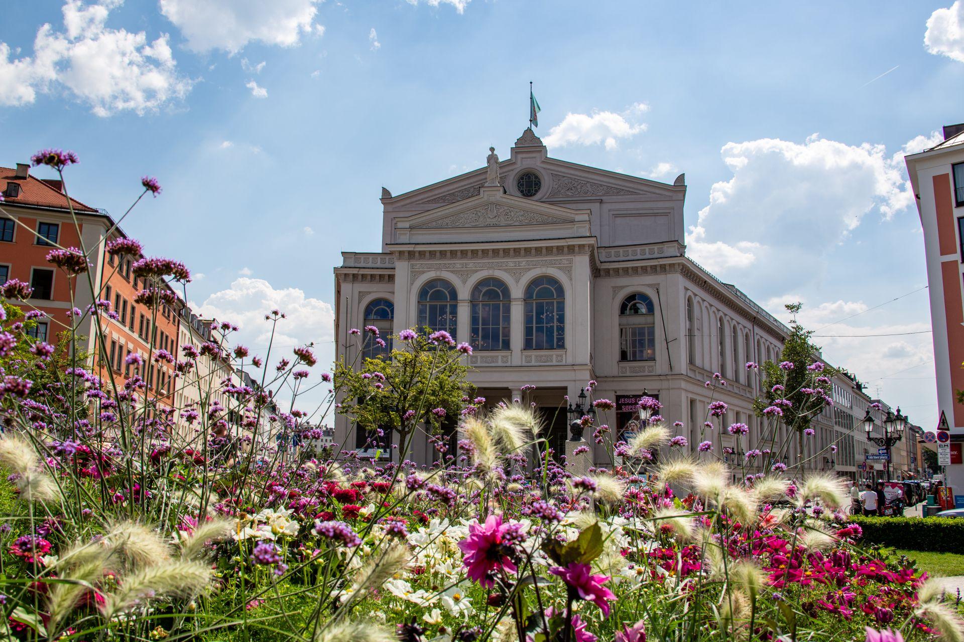 Gaertnerplatz Muenchen mit buntem Blumenbeet und Theater im Hintergrund